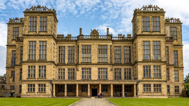 The front entrance of the Elizabethan Hardwick Hall, the building is stone, yellow in the sun and with "more windows than wall"